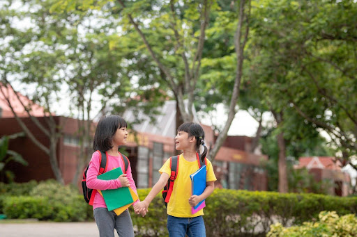 Kids with school bag holding book