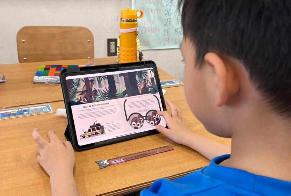 OWIS Osaka Primary school student uses an Apple Tablet (ipad) in the classroom to do research for a reading task
